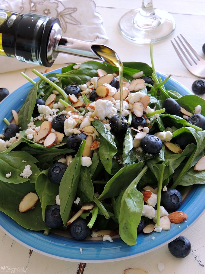 Drizzling Olive Oil Over Spinach Salad
